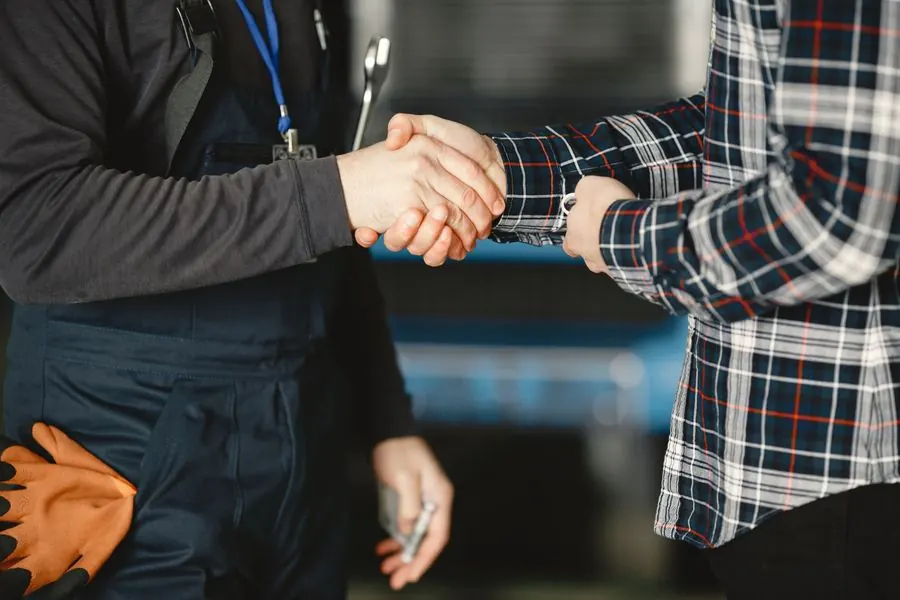 Bear Plumbing technician shaking hands with a customer, representing quality, reliability, and trust